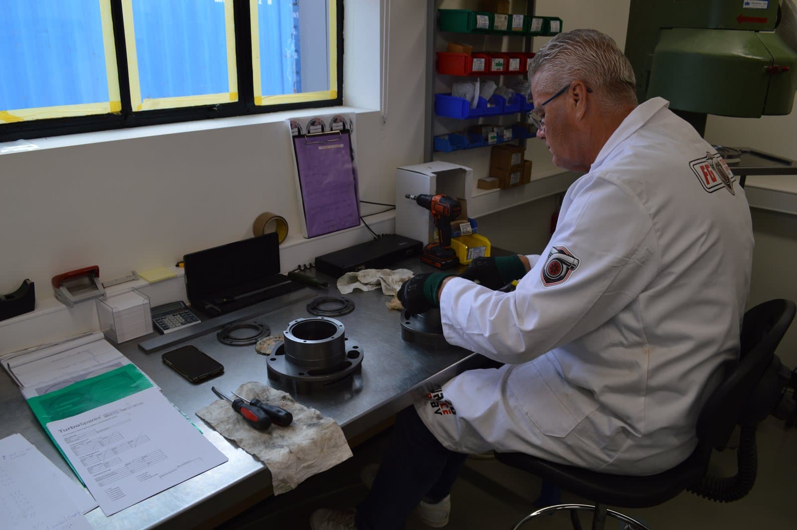FG Turboservices technician measuring a turbocharger bearing housing at the workbench